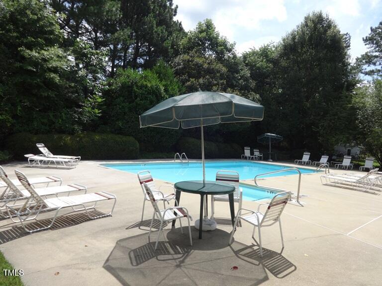 2942 Faversham Place Raleigh, NC 27604 - Photo 8 of 8 a patio with a table and chairs under an umbrella