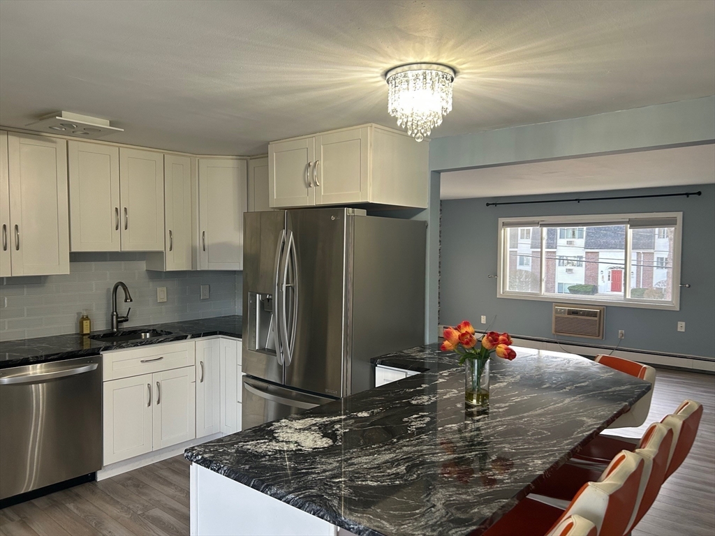 37 Will Drive, Unit 12 Canton, MA 02021 - Photo 5 of 20 a kitchen with stainless steel appliances granite countertop a sink refrigerator and cabinets
