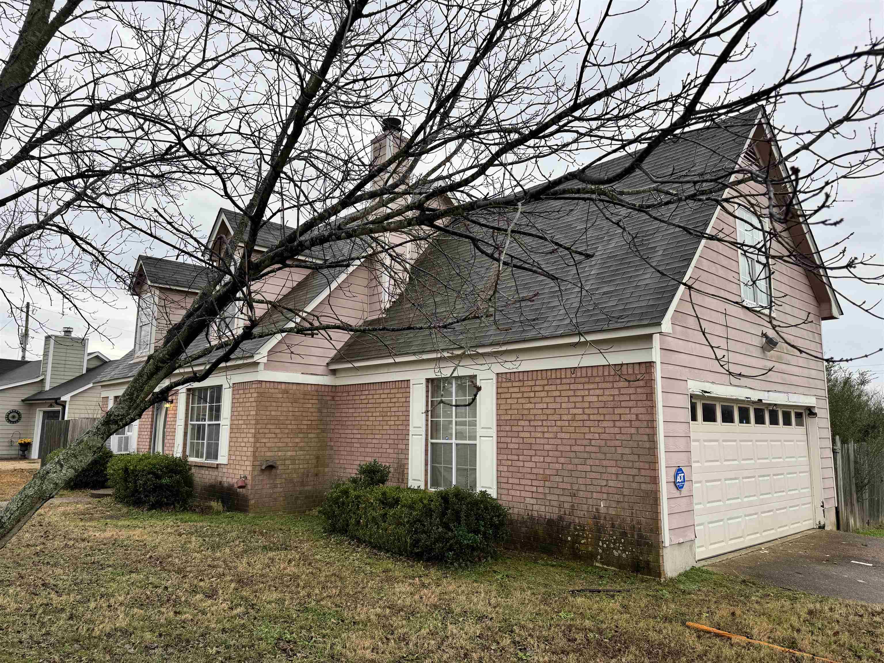 5331 Timber Ridge Drive Memphis, TN 38141 - Photo 3 of 17 View of side of property with brick siding, a garage, roof with shingles, a lawn, and driveway