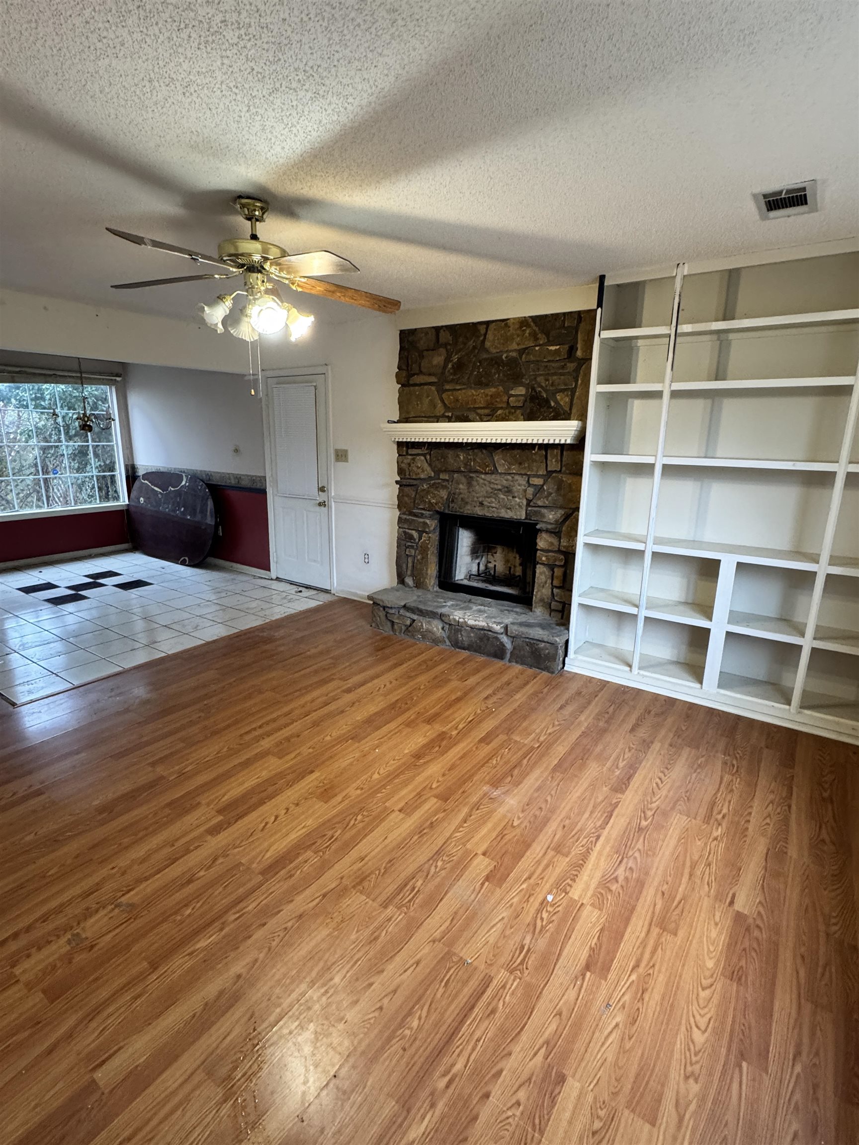5331 Timber Ridge Drive Memphis, TN 38141 - Photo 4 of 17 Unfurnished living room with light wood-type flooring, ceiling fan, a textured ceiling, a fireplace, and built in features