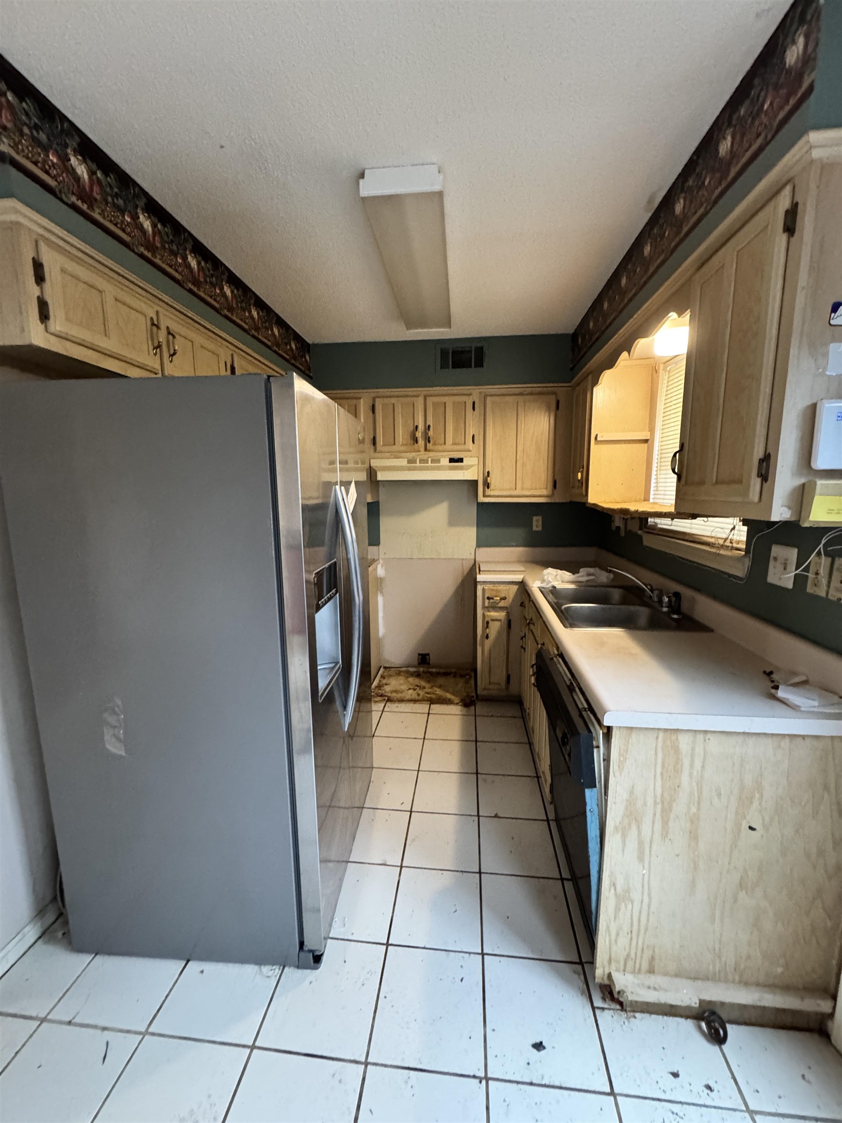 5331 Timber Ridge Drive Memphis, TN 38141 - Photo 5 of 17 Kitchen featuring stainless steel fridge with ice dispenser, light countertops, light tile patterned flooring, a textured ceiling, and dishwashing machine