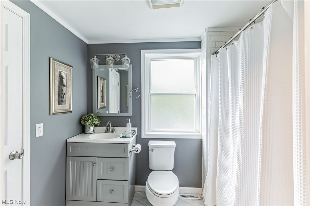27250 Cannon Road Solon, OH 44139 - Photo 5 of 15 Bathroom featuring tile flooring, ornamental molding, mirror, and vanity
