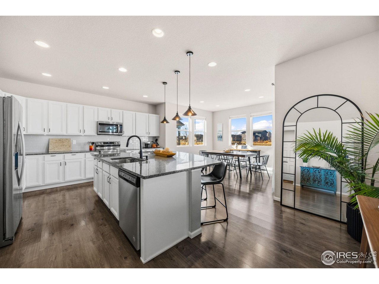 5247 Alberta Falls Street Timnath, CO 80547 - Photo 5 of 43 Kitchen with stainless steel appliances and white cabinetry