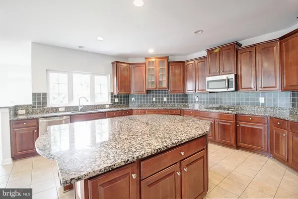 a kitchen with stainless steel appliances granite countertop a stove sink and cabinets