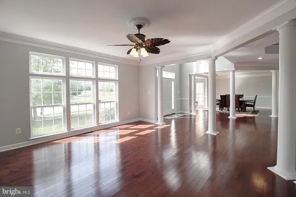 a view of empty room with wooden floor and floor to ceiling window