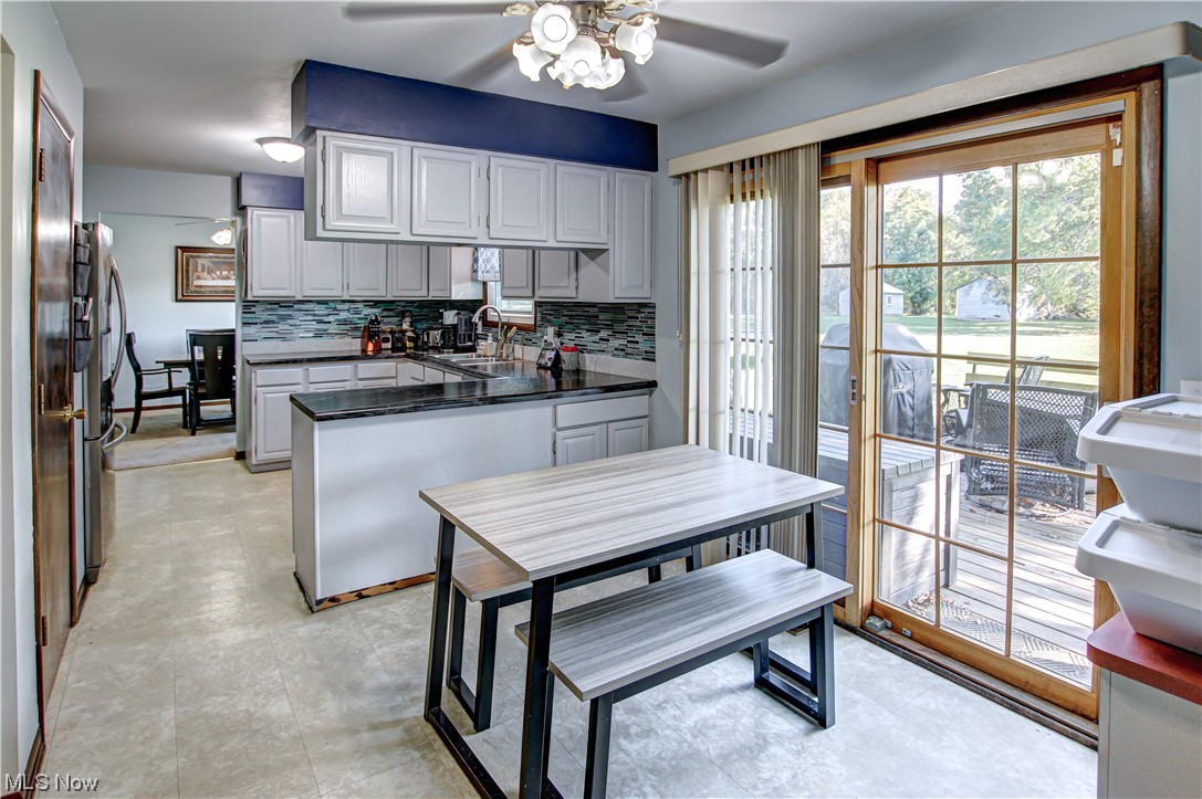 39353 Burns Road North Ridgeville, OH 44039 - Photo 6 of 35 Kitchen featuring light tile floors, ceiling fan, tasteful backsplash, white cabinetry, and countertops dark