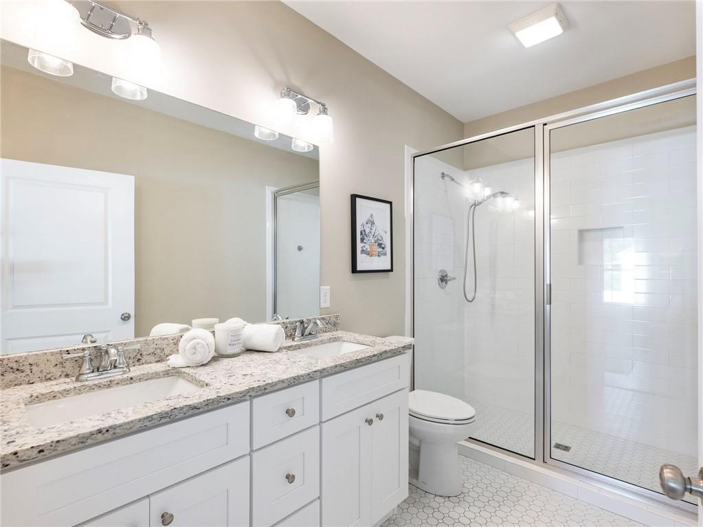 232 Campbell Street Cleveland, GA 30528 - Photo 18 of 37 a bathroom with a granite countertop sink toilet a large mirror a shower and vanity