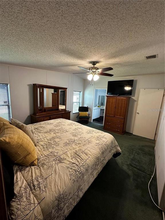 1100 South Belcher Road, Unit 406 Largo, FL 33771 - Photo 10 of 46 a bedroom with a large bed and a chandelier