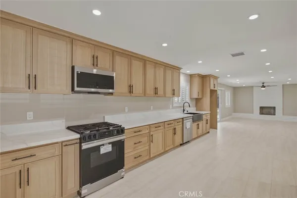 a kitchen with stainless steel appliances granite countertop a stove a sink and a microwave