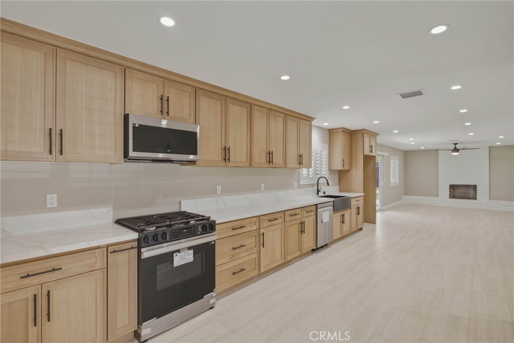 5874 Olive Avenue Rialto, CA 92377 - Photo 1 of 50 a kitchen with stainless steel appliances granite countertop a stove a sink and a microwave