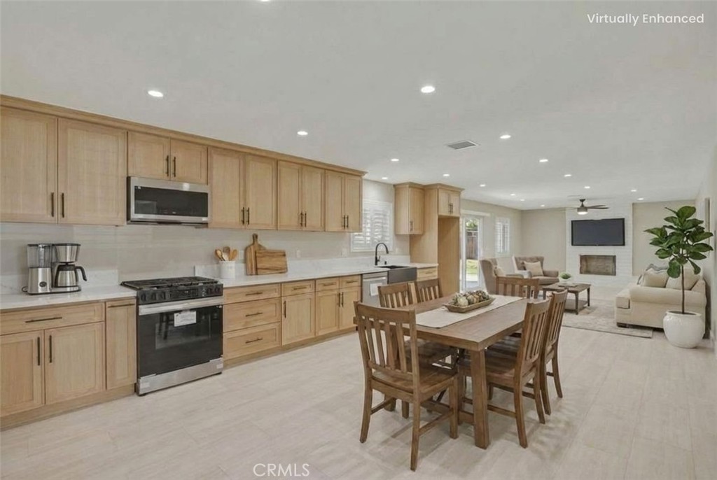 5874 Olive Avenue Rialto, CA 92377 - Photo 2 of 50 a kitchen with a dining table chairs and white cabinets