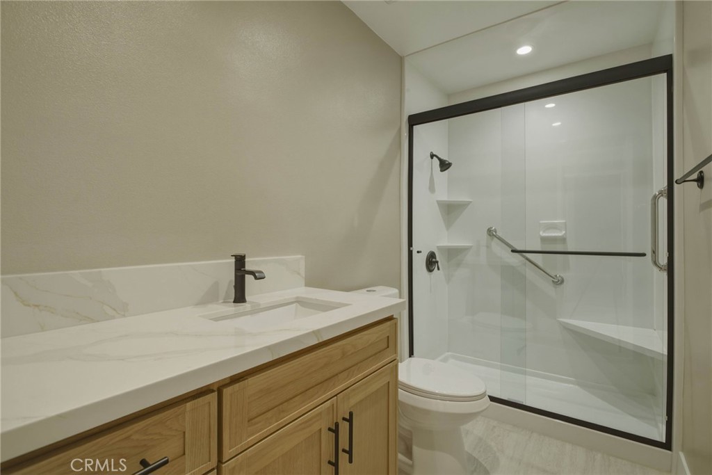 5874 Olive Avenue Rialto, CA 92377 - Photo 29 of 50 a bathroom with a granite countertop sink toilet and shower