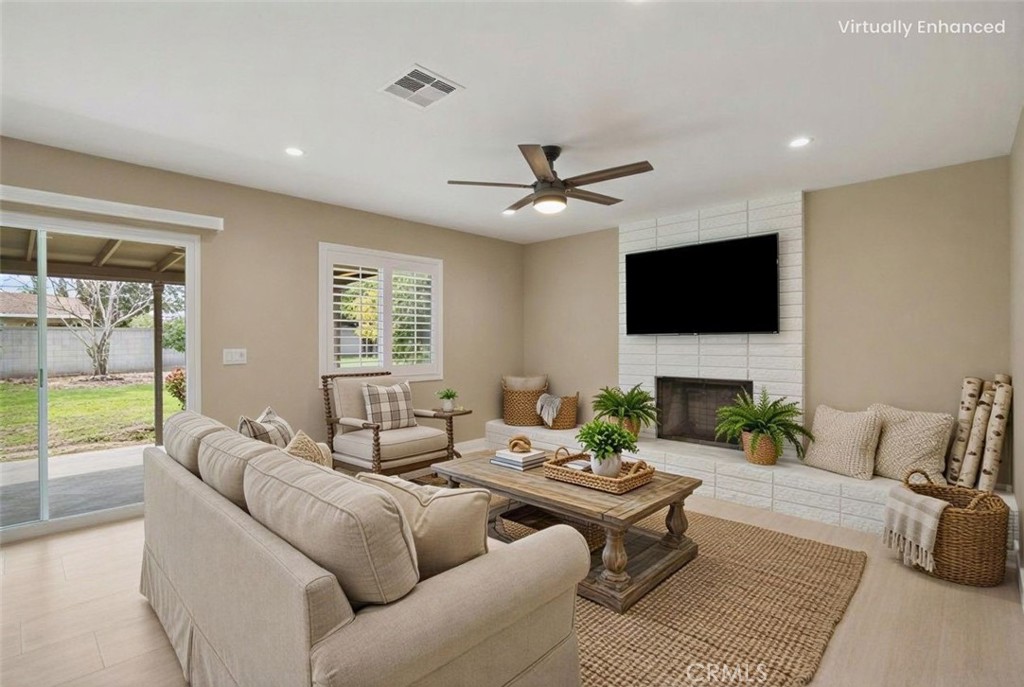 5874 Olive Avenue Rialto, CA 92377 - Photo 4 of 50 a living room with furniture a flat screen tv and a large window