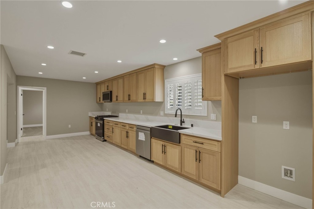 5874 Olive Avenue Rialto, CA 92377 - Photo 5 of 50 a large kitchen with stainless steel appliances granite countertop a lot of counter space and a sink