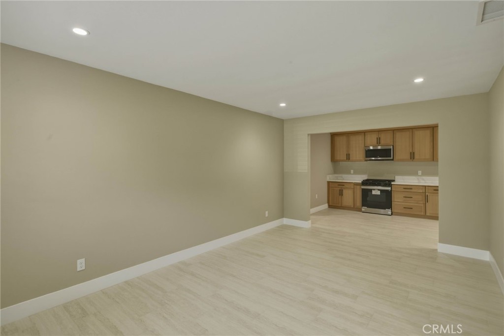5874 Olive Avenue Rialto, CA 92377 - Photo 7 of 50 a view of a kitchen with a sink and dishwasher a stove top oven with wooden floor