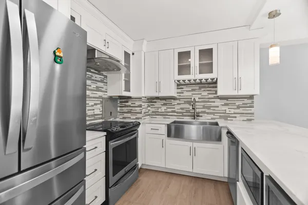 a kitchen with stainless steel appliances a stove a sink and a refrigerator