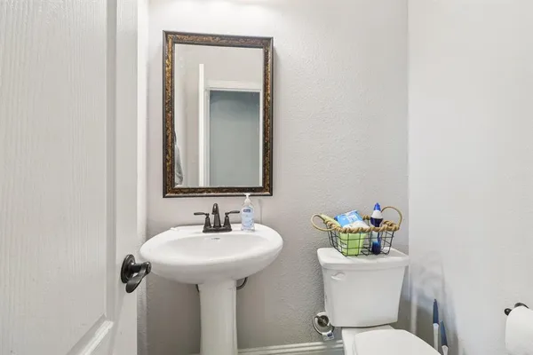 a bathroom with a toilet sink and mirror