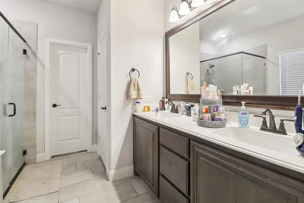 a bathroom with a double vanity sink a mirror and a shower