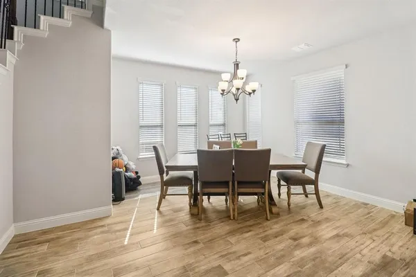 a dining room with furniture wooden floor a rug and a chandelier