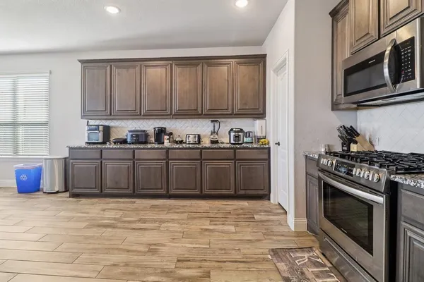 a kitchen with stainless steel appliances a stove a sink and a microwave