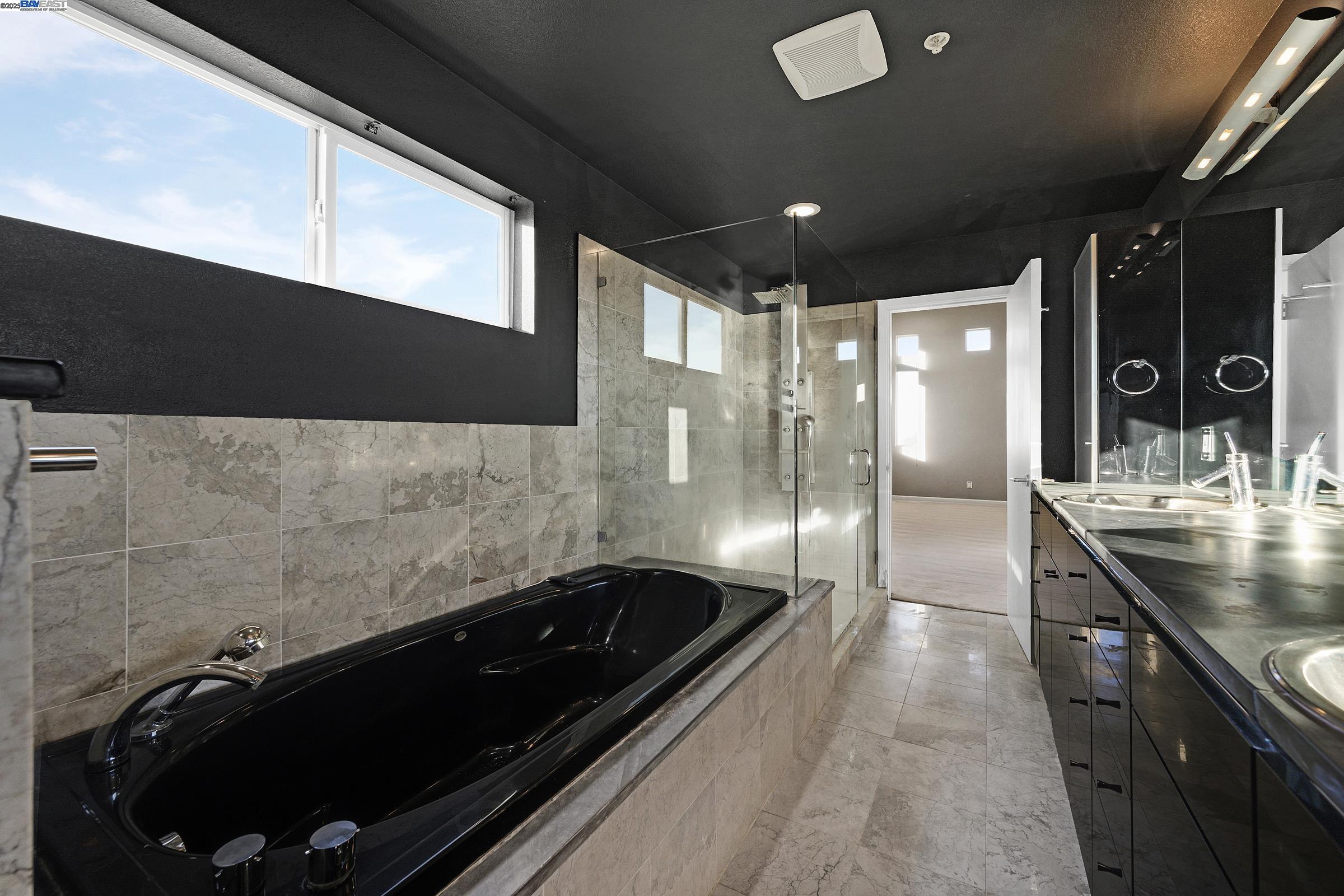 17011 North Midway Road Tracy, CA 95377 - Photo 31 of 52 a bathroom with a double vanity sink a large mirror and shower