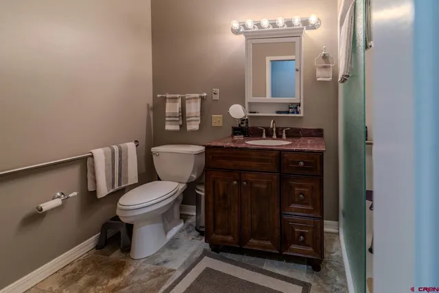 a bathroom with a toilet a sink and mirror