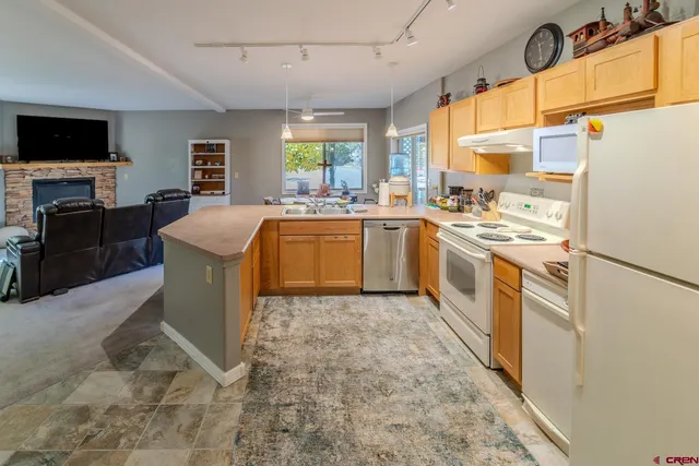 a kitchen with a sink a stove top oven a refrigerator and furniture