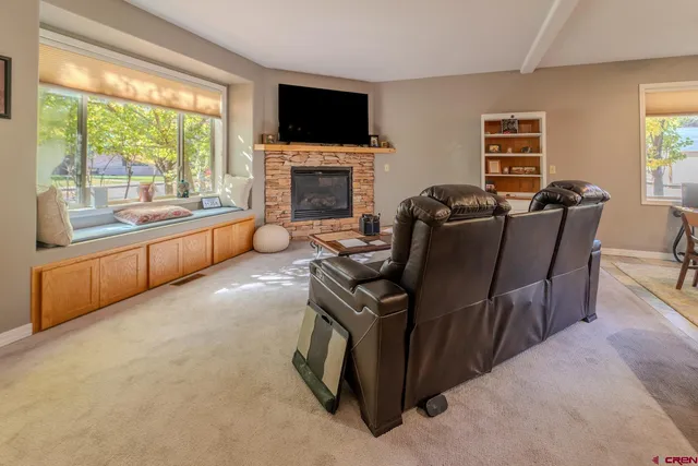 a living room with furniture a flat screen tv and a fireplace