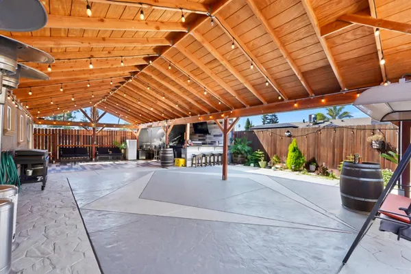 a view of a patio with table and chairs under an umbrella