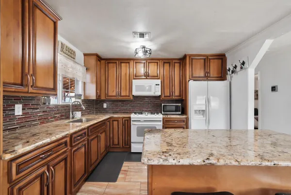 a kitchen with stainless steel appliances granite countertop a sink stove and refrigerator