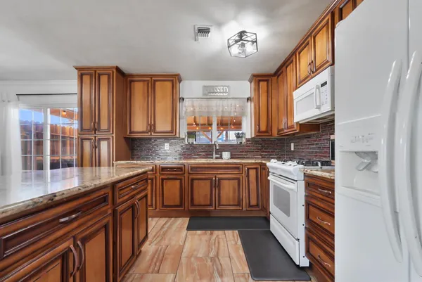 a kitchen with stainless steel appliances granite countertop a stove and cabinets