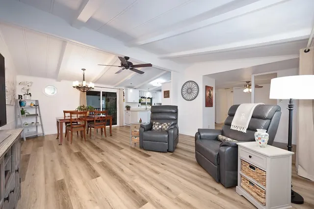 a dining room with wooden floor a chandelier a wooden table and chairs