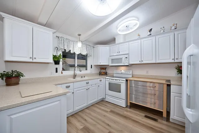 a kitchen with white cabinets and white appliances