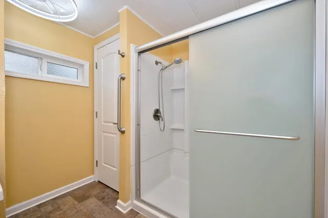 a spacious bedroom with a bed and a chandelier
