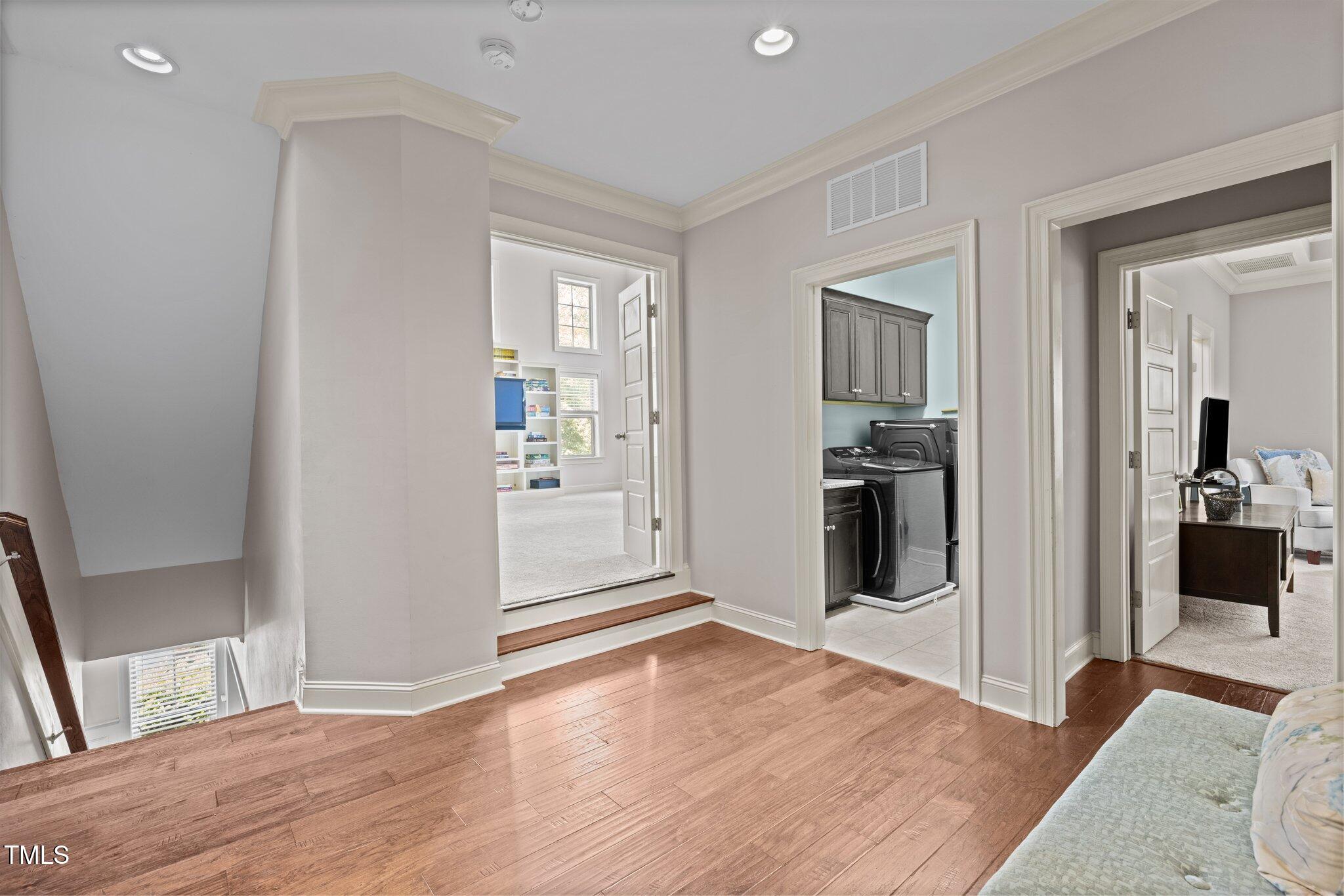 12216 Kyle Abbey Lane Raleigh, NC 27613 - Photo 26 of 60 a view of a kitchen and an empty room with wooden floor and a kitchen