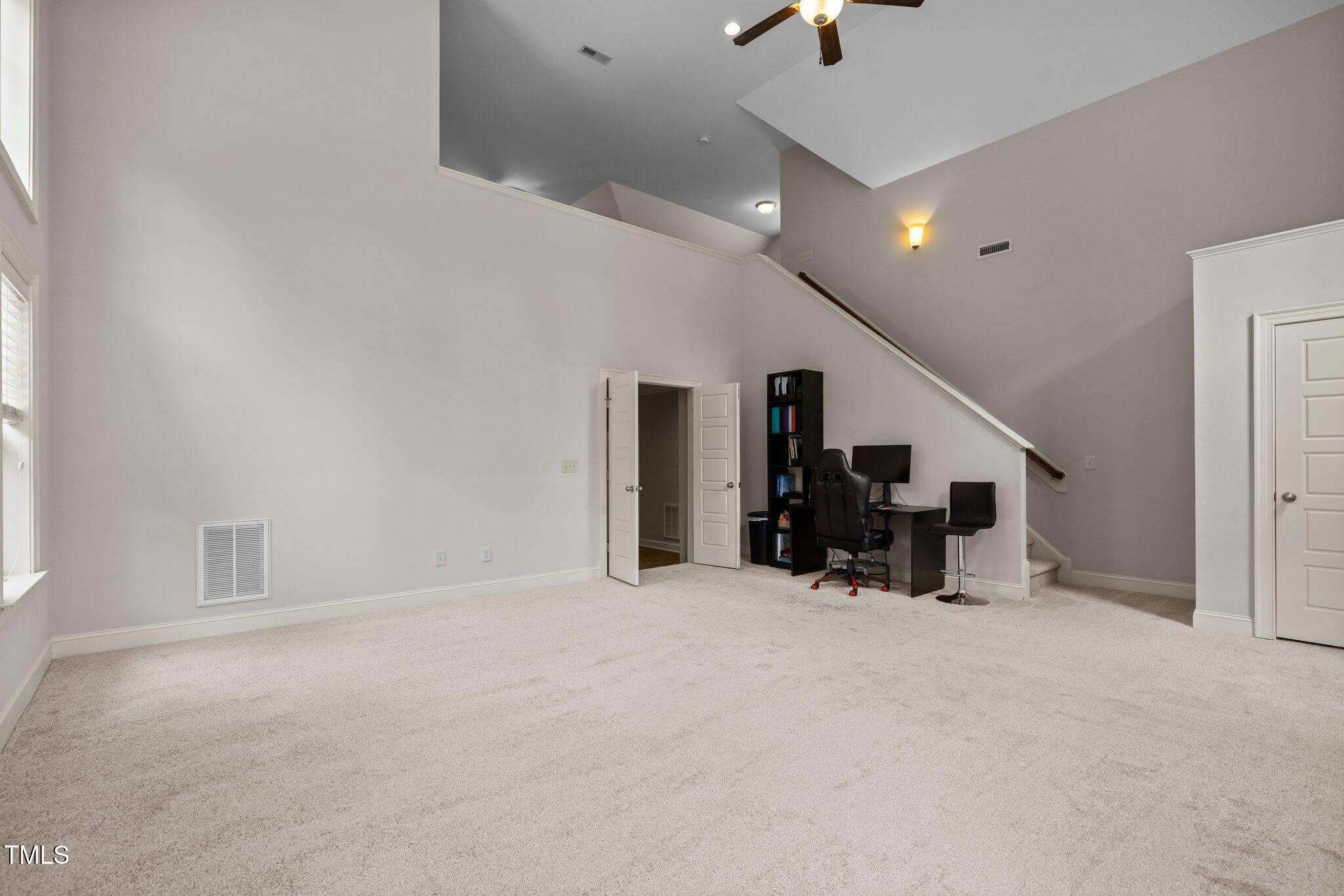 12216 Kyle Abbey Lane Raleigh, NC 27613 - Photo 29 of 60 an empty room with closet and a chandelier fan