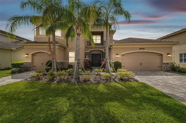 a front view of a house with a yard and potted plants