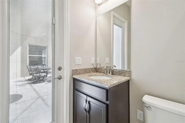 a bathroom with a granite countertop sink a toilet and shower