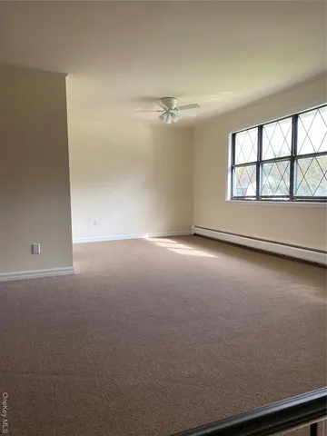 en empty room with windows and ceiling fan