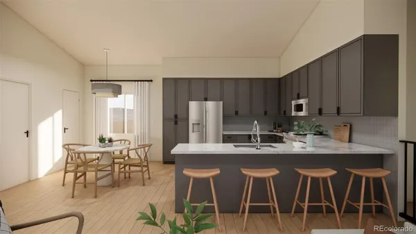 a kitchen with stainless steel appliances granite countertop a table chairs and a refrigerator