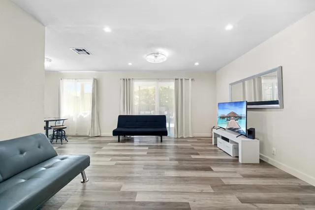 a living room with furniture and a wooden floor