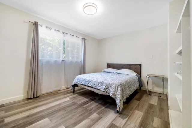 a bedroom with a bed lamp and a large window