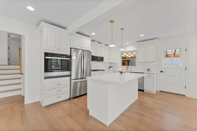 a kitchen with white cabinets and stainless steel appliances
