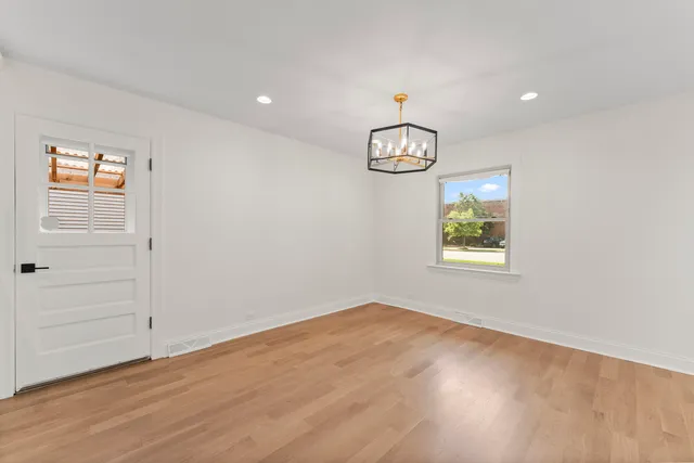 an empty room with window and wooden floor