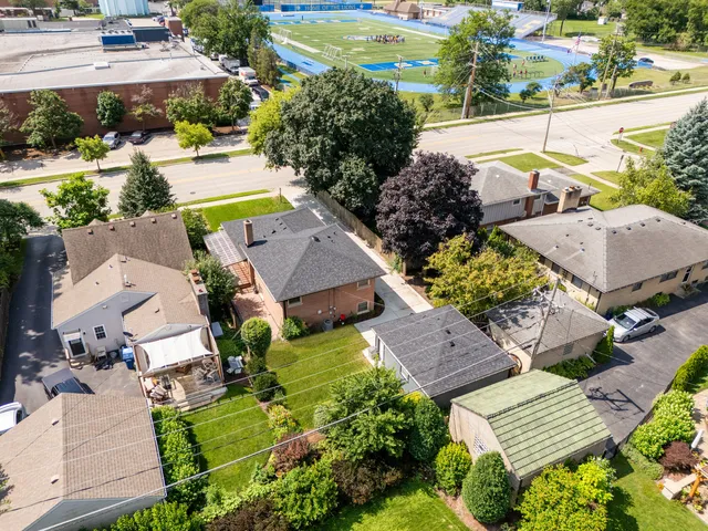 an aerial view of residential houses with outdoor space and trees