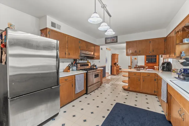a kitchen with granite countertop stainless steel appliances a stove refrigerator and cabinets