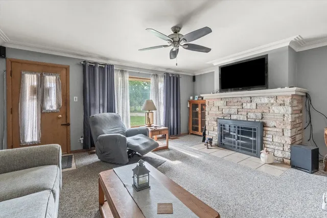 a living room with furniture a flat screen tv and a fireplace