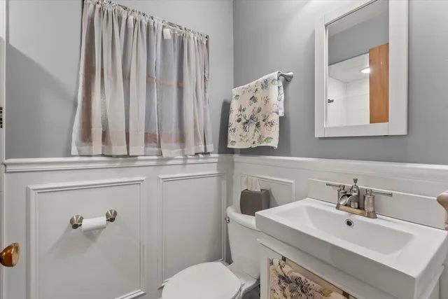 a bathroom with a sink and mirror with toilet