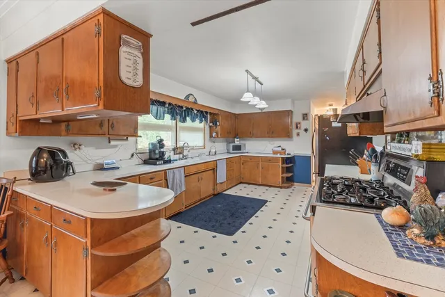 a kitchen with stainless steel appliances a stove a sink dishwasher and cabinets with wooden floor