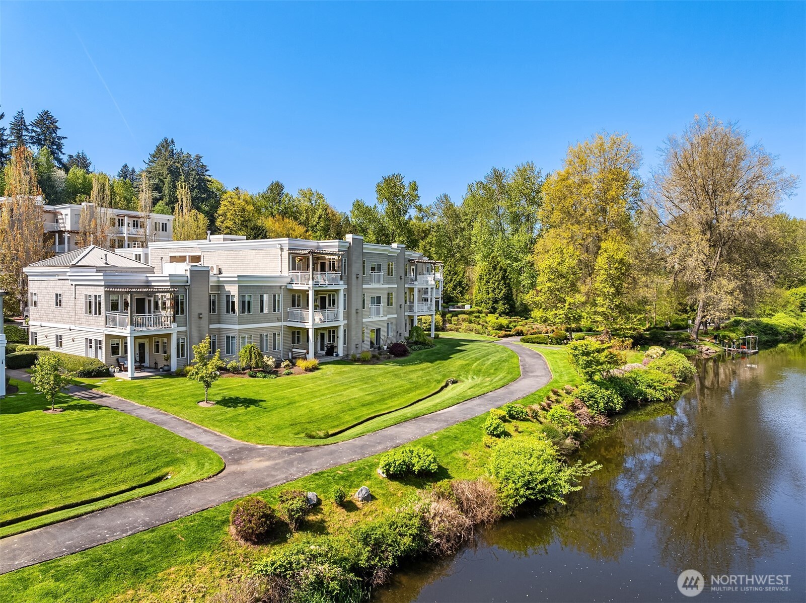 17432 Bothell Way Northeast, Unit B302 Bothell, WA 98011 - Photo 2 of 38 a view of a white house with a big yard and large trees